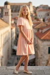 Abito Sia rosa per bambina – figura intera con la torre del centro storico sullo sfondo