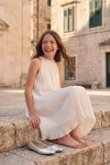 Abito Rozalia bianco plissé all'aperto – ragazza seduta su una scalinata di pietra
