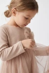 Abito Iga beige – fiocco di tulle sul petto e corpetto in maglina a maniche lunghe, primo piano laterale