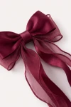 Fermaglio per capelli con fiocco bordeaux – primo piano del raso lucido e dell'organza trasparente
