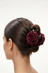 Pinza per capelli con rosa bordeaux appuntata su uno chignon – vista da dietro