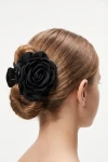 Pinza per capelli nera con rosa in tessuto appuntata su uno chignon basso – vista da dietro