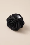 Pinza per capelli nera con rosa in tessuto su fondo beige – vista di tre quarti